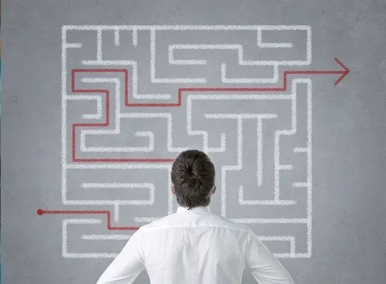 Entrepreneur se questionnant devant un labyrinthe de solutions