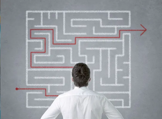 Entrepreneur se questionnant devant un labyrinthe de solutions