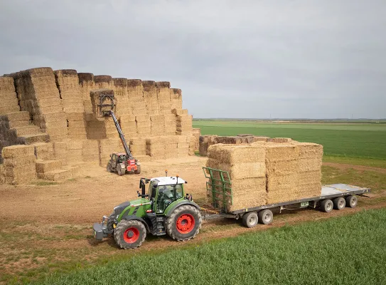 Tracteur déplaçant des bottes de paille pour valoriser les produits agricoles